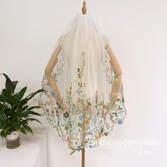 a dress on a mannequin next to a potted plant and a white wall