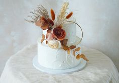 a white cake with flowers and feathers on top