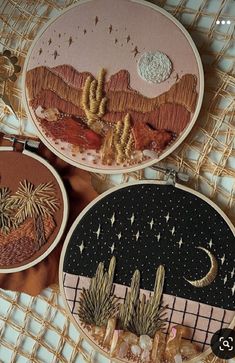 three hand embroidered hoops with desert scenes on them, one in gold and the other in black