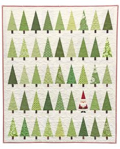 a quilted christmas tree pattern with santa's hat on top and trees in the background