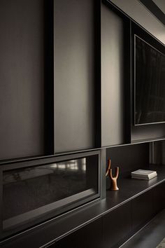 an empty room with black walls and shelves