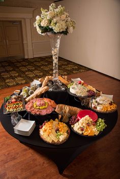 a table topped with lots of different types of food on top of a wooden floor