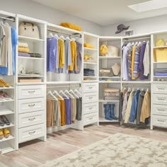 an organized walk in closet with white drawers and open shelving units filled with clothes