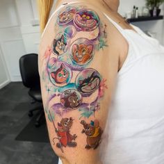 a woman with a tattoo on her arm has many images of cartoon characters in it