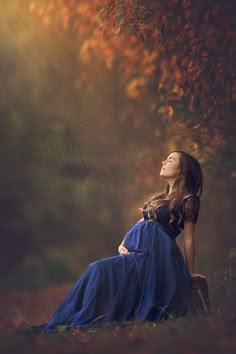 a woman is laying down in the grass with her eyes closed and she is wearing a blue dress