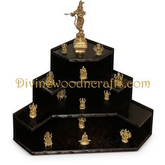 three tiered black and gold plated trays with figurines on them