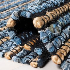 a pile of blue and black rugs sitting on top of a white floor next to each other