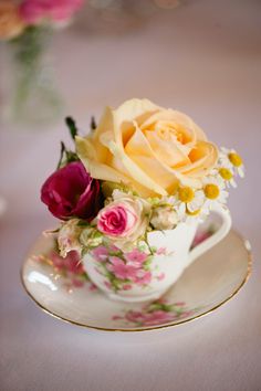 a tea cup with flowers in it on a table