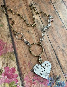 "v'¯) .`*.¸.*'❤ OnE KiNd WorD ~  BELIEVE ❤ This DESIGN ~ Hand-stamped \"believe\" onto an aluminum heart. 18\" chain is comprised of clear vintage glass bead chain and gray bead chain. All held together with lots of unique connectors. jewelry for your heart & soul <-----❤---- NOTE ❤ ---> The listing photos you are seeing are of my original designs. I only change the photos when there is a significant design difference. What this means is, you may receive: a necklace with a different type of bead/charm; a slight difference to the leather pattern; placement/style of rivets on the leather, size of glass bead chain etc." Metal Stamped Necklace, Jewelry 2023, Pewter Jewelry, Jewelry Styles, Hand Stamped Necklace, Grey Beads, Metal Necklace, Assemblage Art, Bead Chain