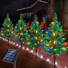 solar powered christmas trees with lights in front of a house