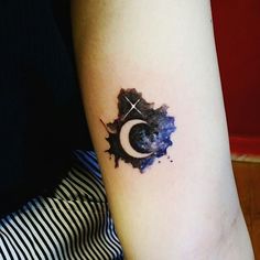 a person with a tattoo on their arm that has the moon and star in it