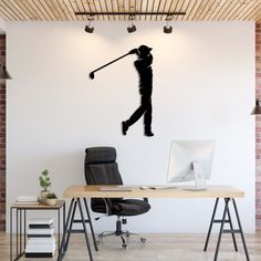 a man swinging a golf club on top of a wooden desk in front of a white wall