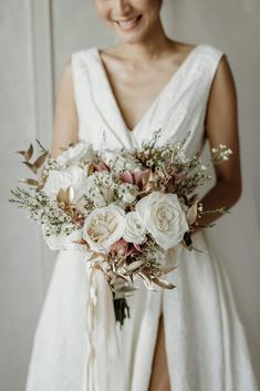 a woman in a white dress holding a bridal bouquet