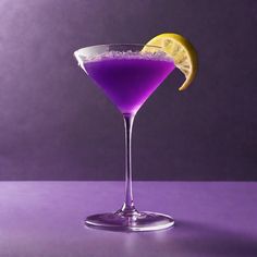 a purple drink with a lemon slice on the rim and sugar in the garnish