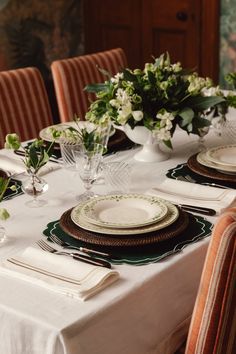 the table is set with plates and place settings