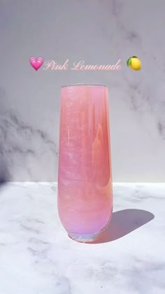 a pink vase sitting on top of a marble counter next to lemons and an inscription that reads pink lemonade