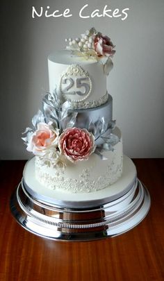 a three tiered wedding cake with flowers on the top and number 25 on the bottom