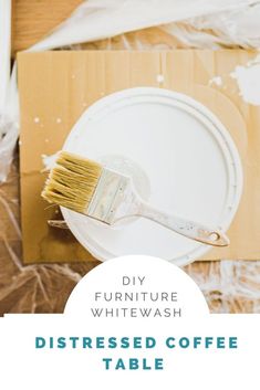 a paintbrush sitting on top of a white plate next to a cardboard box with the words diy furniture whitewash