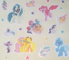 many different stickers are shown on the wall in front of a bed sheet with an image of ponies