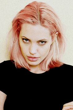 a woman with pink hair is posing for the camera