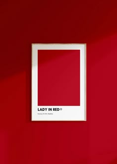 a red wall with a white frame hanging on it's side that says lady in red