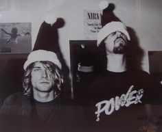 black and white photograph of two men wearing santa hats