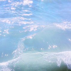 a person riding a surfboard on top of a wave in the ocean at night