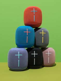 three bluetooth speakers with crosses on them sitting on top of each other in front of a green background