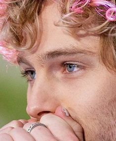 a close up of a person with pink hair and ring on his nose, looking to the side