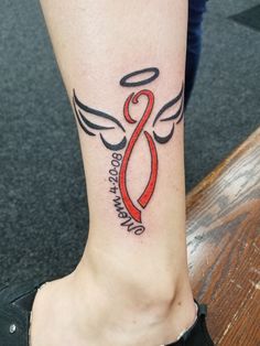 a woman's foot with a red ribbon and angel wings tattoo on the ankle