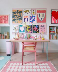 a pink desk with pictures on the wall