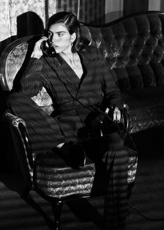 a woman sitting in a chair talking on the phone