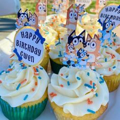 cupcakes with white frosting and colorful decorations