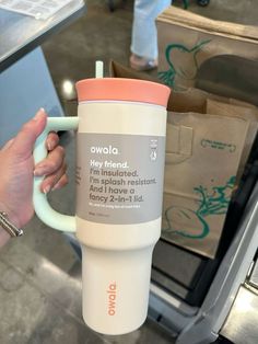 a person holding a coffee cup in their hand with the words owlla on it