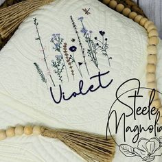 a close up of a cake on a table with flowers and tassels around it