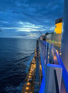 the deck of a cruise ship at night with lights on it's railings