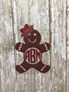 a red and white teddy bear with a bow on it's head sitting against a wooden wall