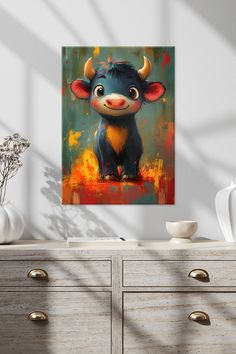 a painting of a bull with horns on it's head sitting in front of a dresser