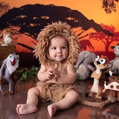 a baby sitting on the ground in front of stuffed animals and other toy figurines