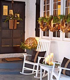 the front porch is decorated for christmas with white rocking chairs and wreaths on them