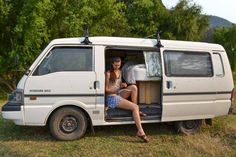 a woman sitting in the open door of a van