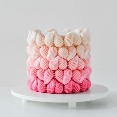 a cake with pink and white frosting stacked on top of each other in the shape of hearts