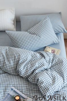 a blue and white checkered comforter on top of a bed with two pillows