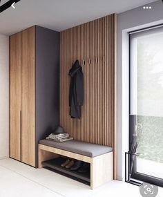 a wooden bench sitting in front of a window next to a coat rack and shoes