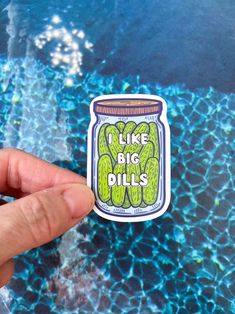 a hand holding up a sticker that says i like big dills in a jar