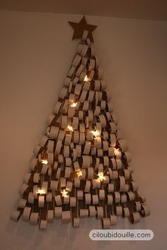 a christmas tree made out of books with candles in the shape of cubes and stars