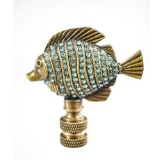 a gold and blue fish figurine sitting on top of a wooden stand with crystal stones