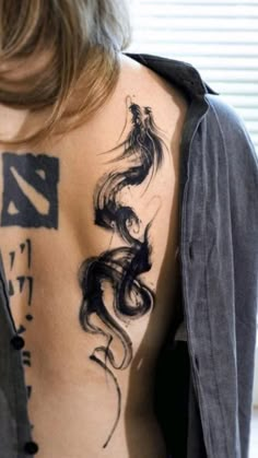 a woman with a dragon tattoo on her back