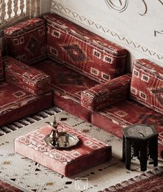 a living room with red couches and rugs on the floor, including a coffee table