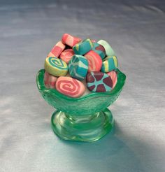 a green glass bowl filled with colorful candy